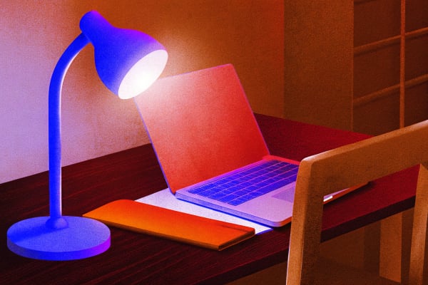 Reading lamp on a dark desk with a lavender glow on an open journal, minimalist habit tracker deep dive