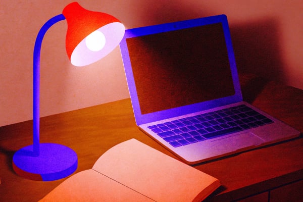 Reading lamp on a dark desk with a lavender glow on an open laptop, Cursor build sprint