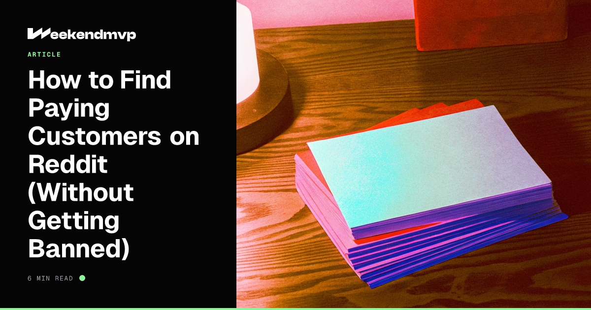 A stack of index cards on a dark desk, the top card catching a single mint side light, shallow focus